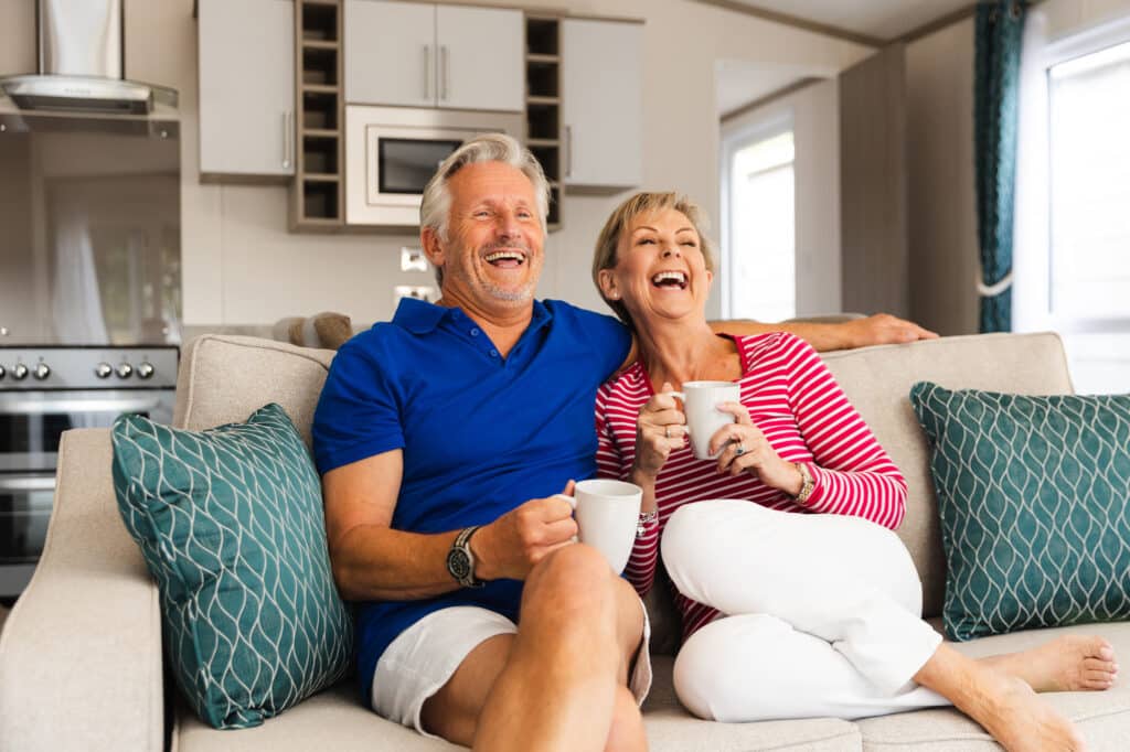 Happy couple relaxing together inside a cosy holiday home.