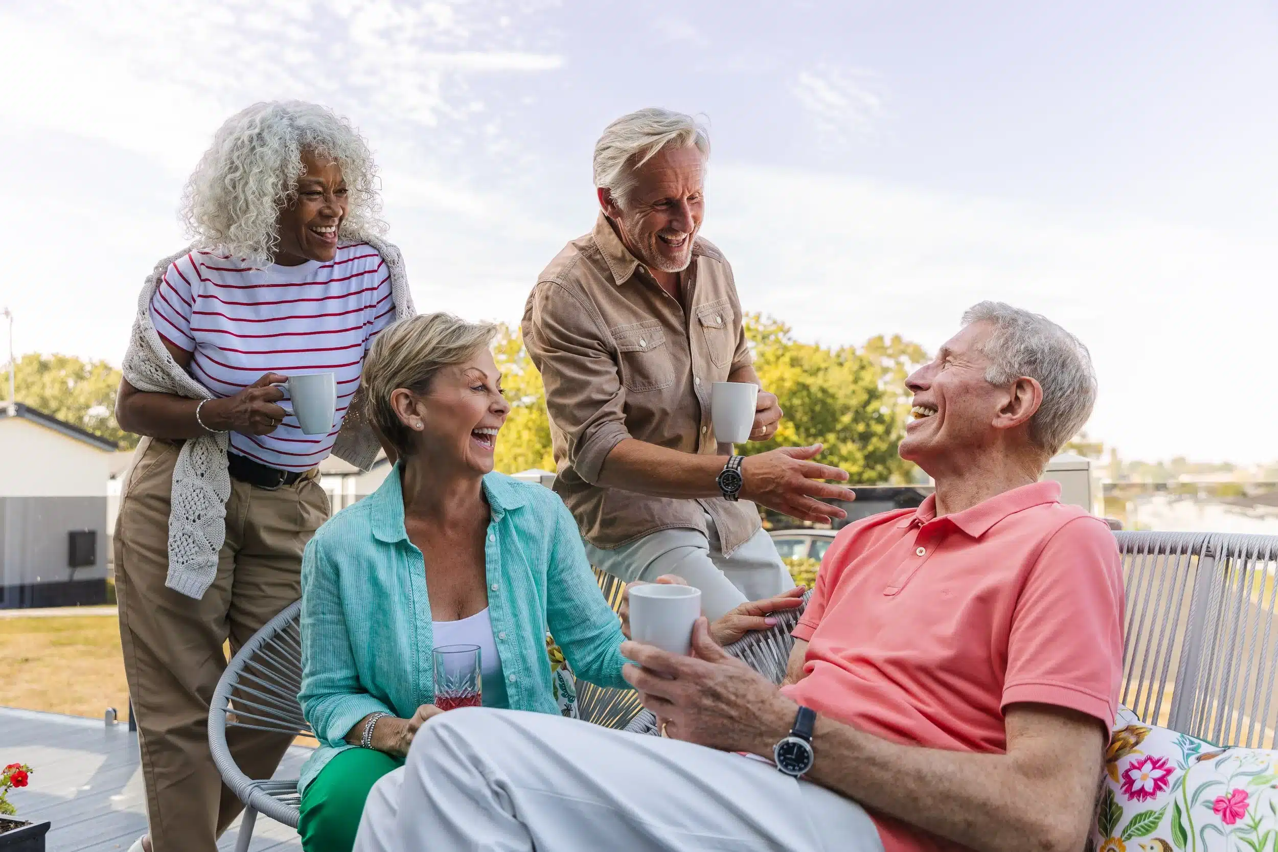 Friends sharing laughter at a holiday park, clear skies