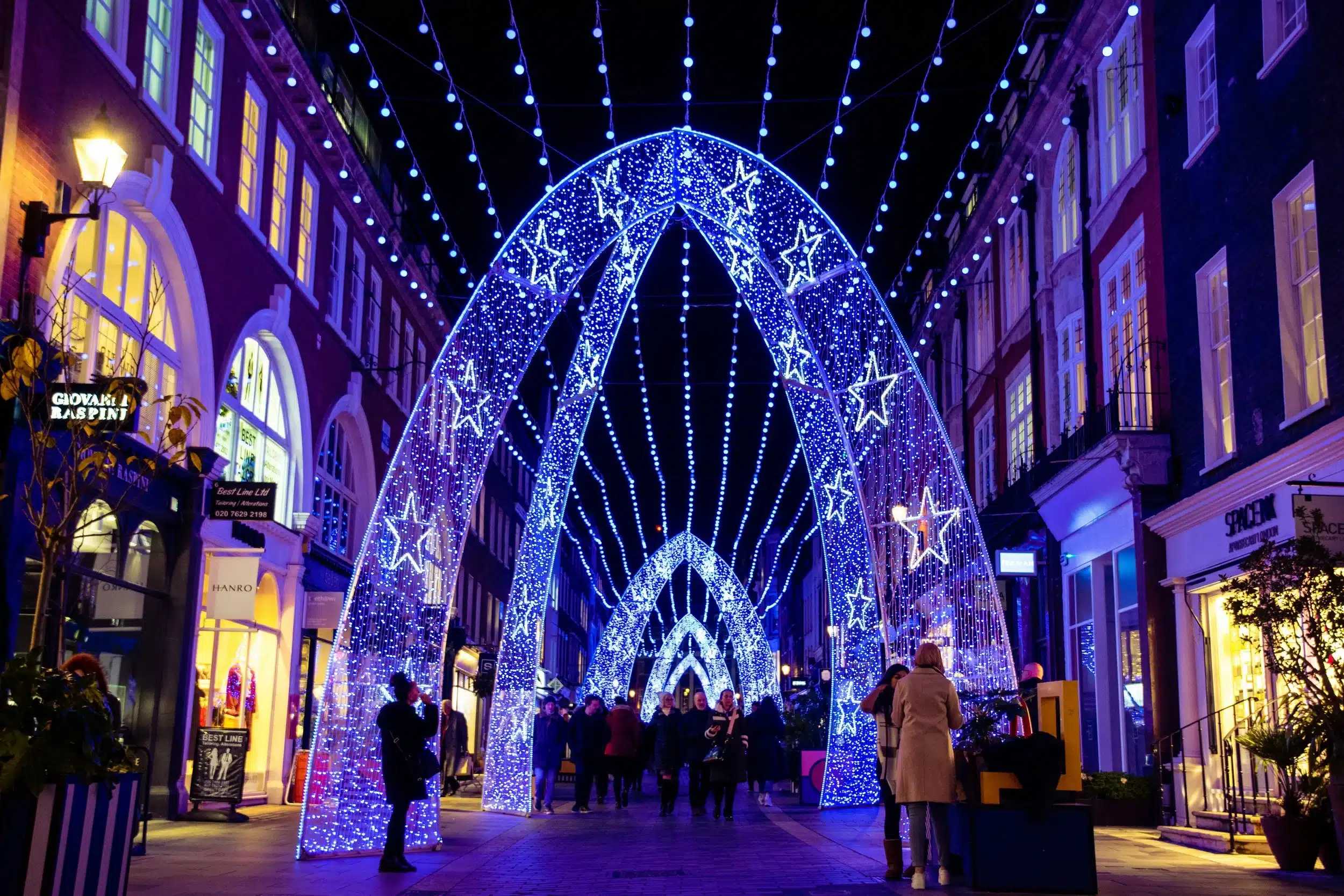 Busy Norwich market with Christmas lights and decorations.