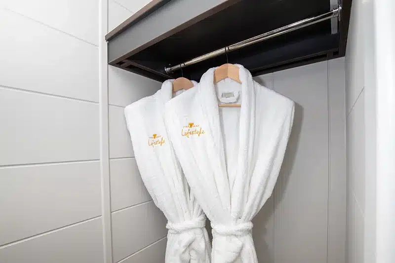 The Ultimate Guide to Buying a Holiday Home in Norfolk and Suffolk 9 White robes hanging up with Tingdene Lifestyle branding