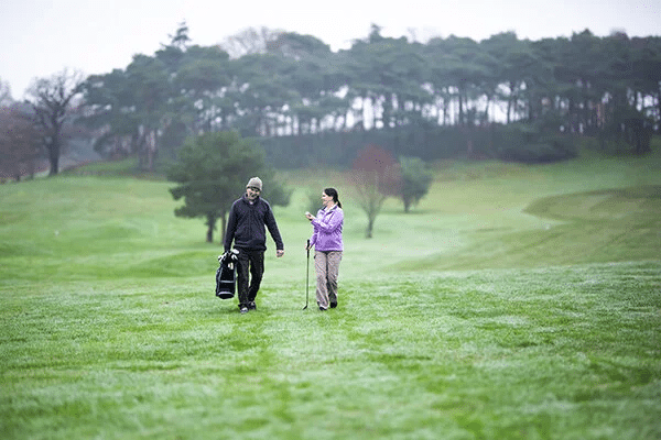 Man and woman walking on golf course