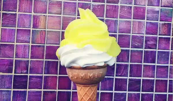 Close-up of a classic lemon top ice cream cone with a swirl of lemon sorbet on top of vanilla