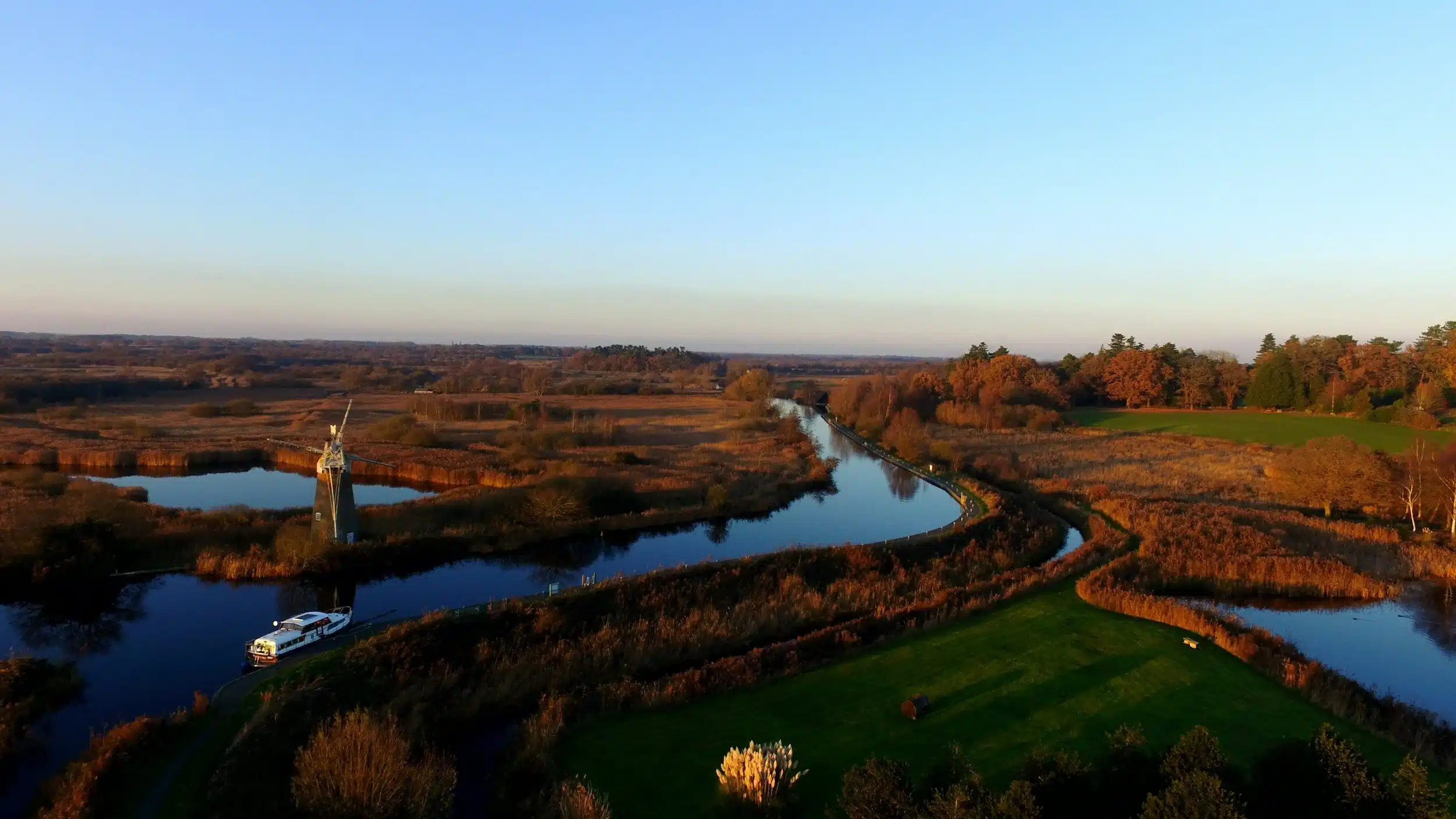 Scenic view of the Broads National Park with boats and windmills – one of the best places to visit in Norfolk and Suffolk.