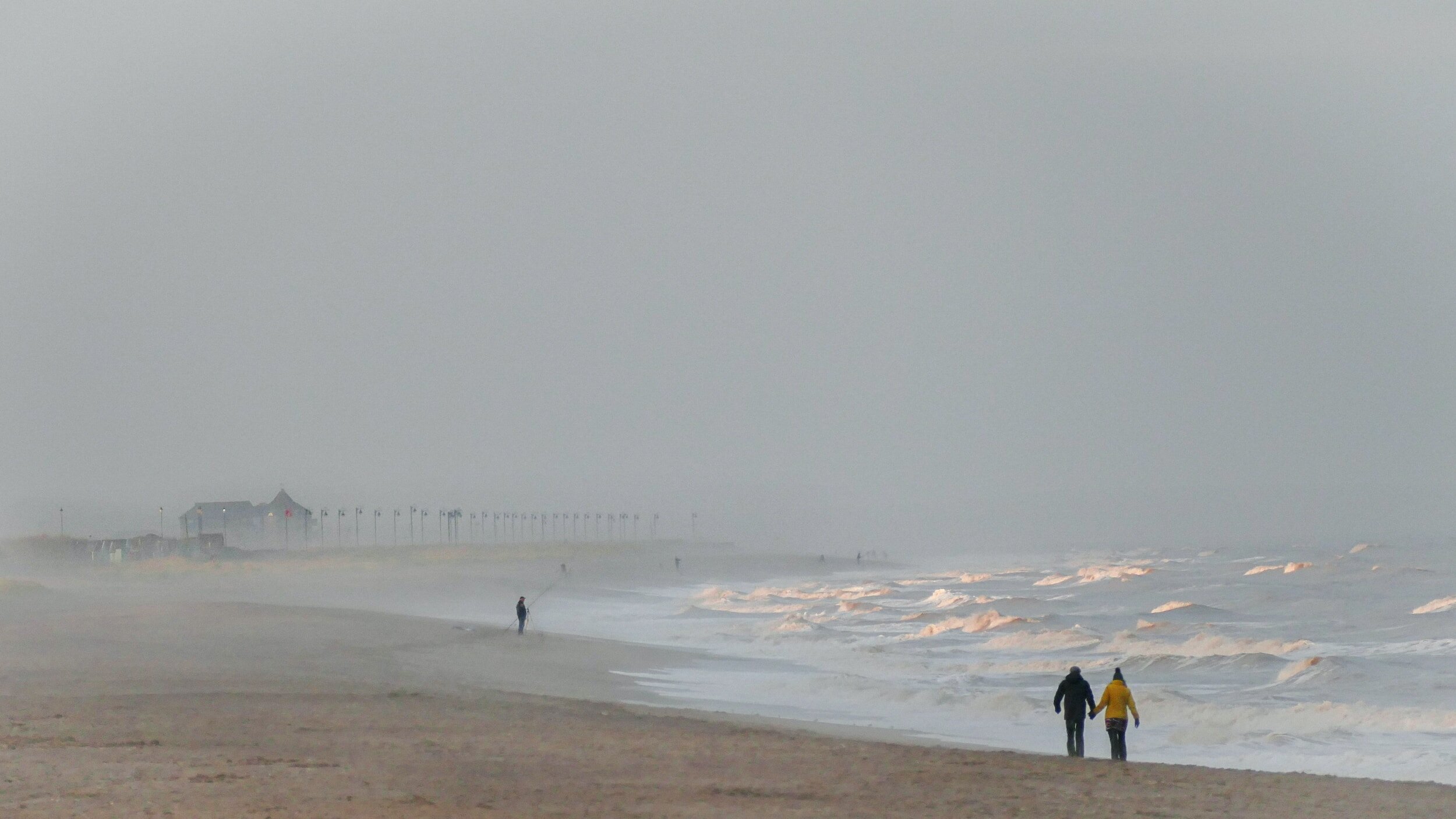 People walking along the shoreline on a Lincolnshire beach