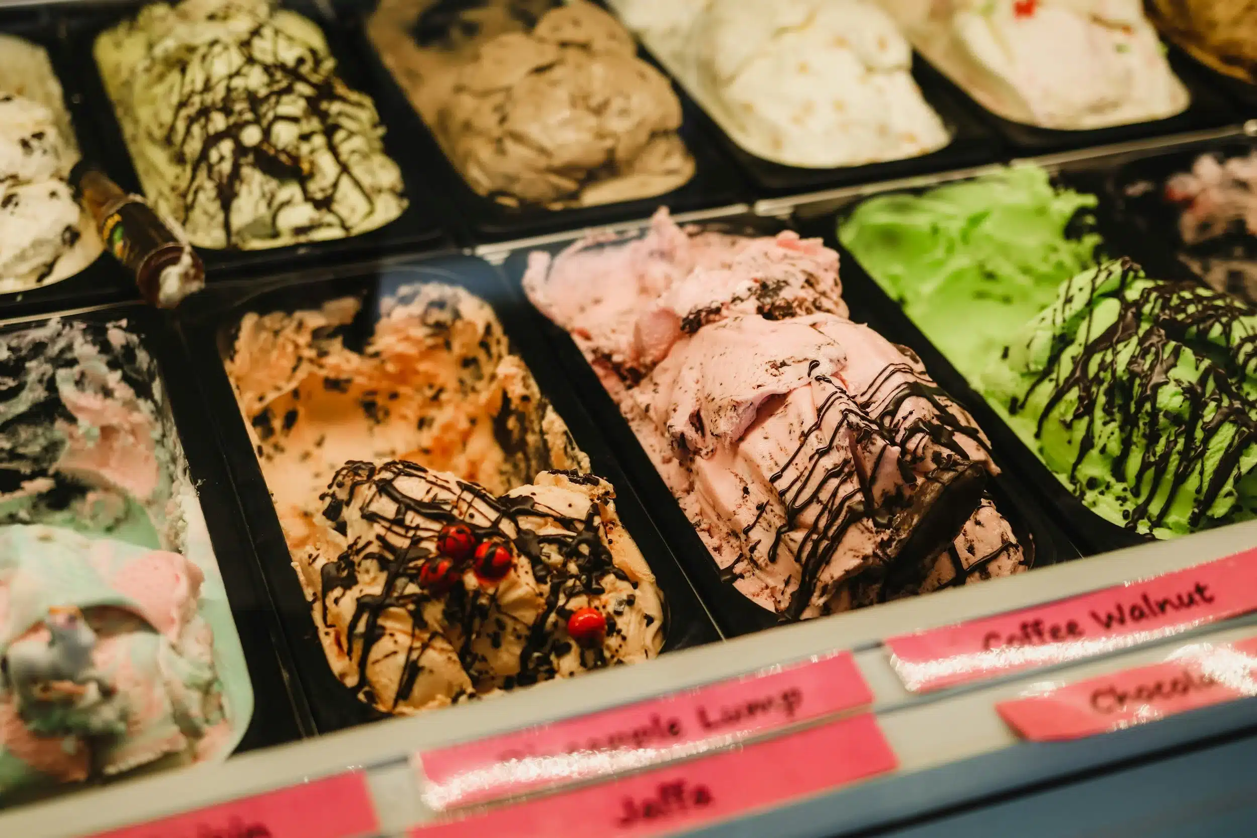 Display of multiple colourful ice cream flavours in a parlour counter