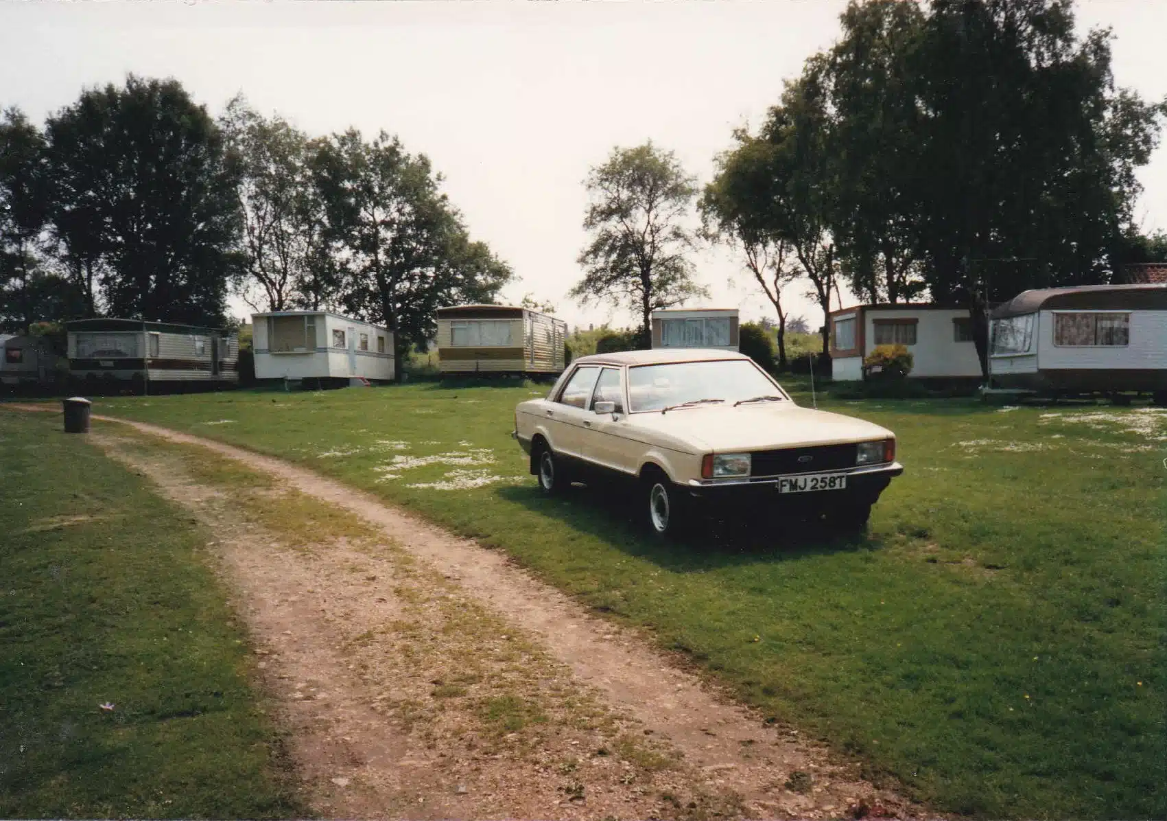 Vintage view of Broadlands Park & Marina with caravans lined up and a car parked in front