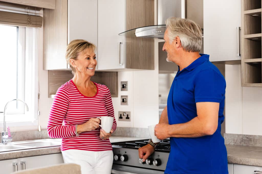 Couple enjoying coffee in kitchen.