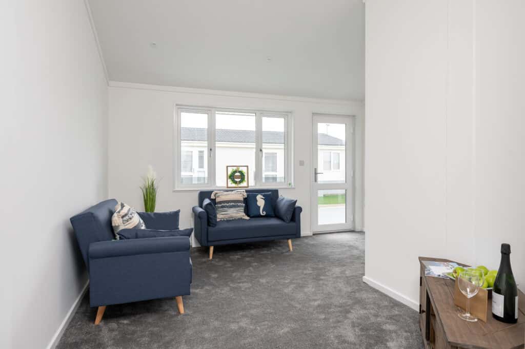 Save the dates for our upcoming events at South Shore Park 5 A living room featuring two blue chairs positioned around a small table.