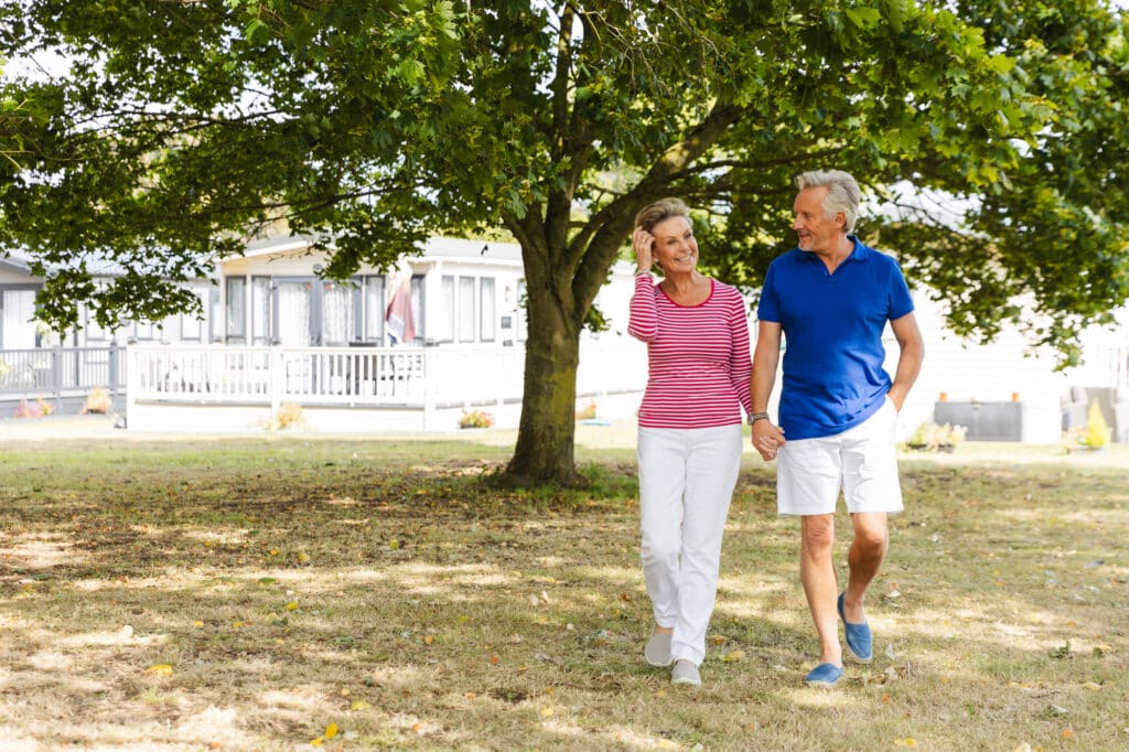 Caldecott Hall Country Park Tea, Cake & Tour Open Day – 11th July 2026 1 A couple walking along the holiday park. With static caravans behind them.